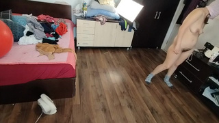 Une femme homemade s'amuse à essayer des vêtements et à les couper. Une femme homemade danse nue dans